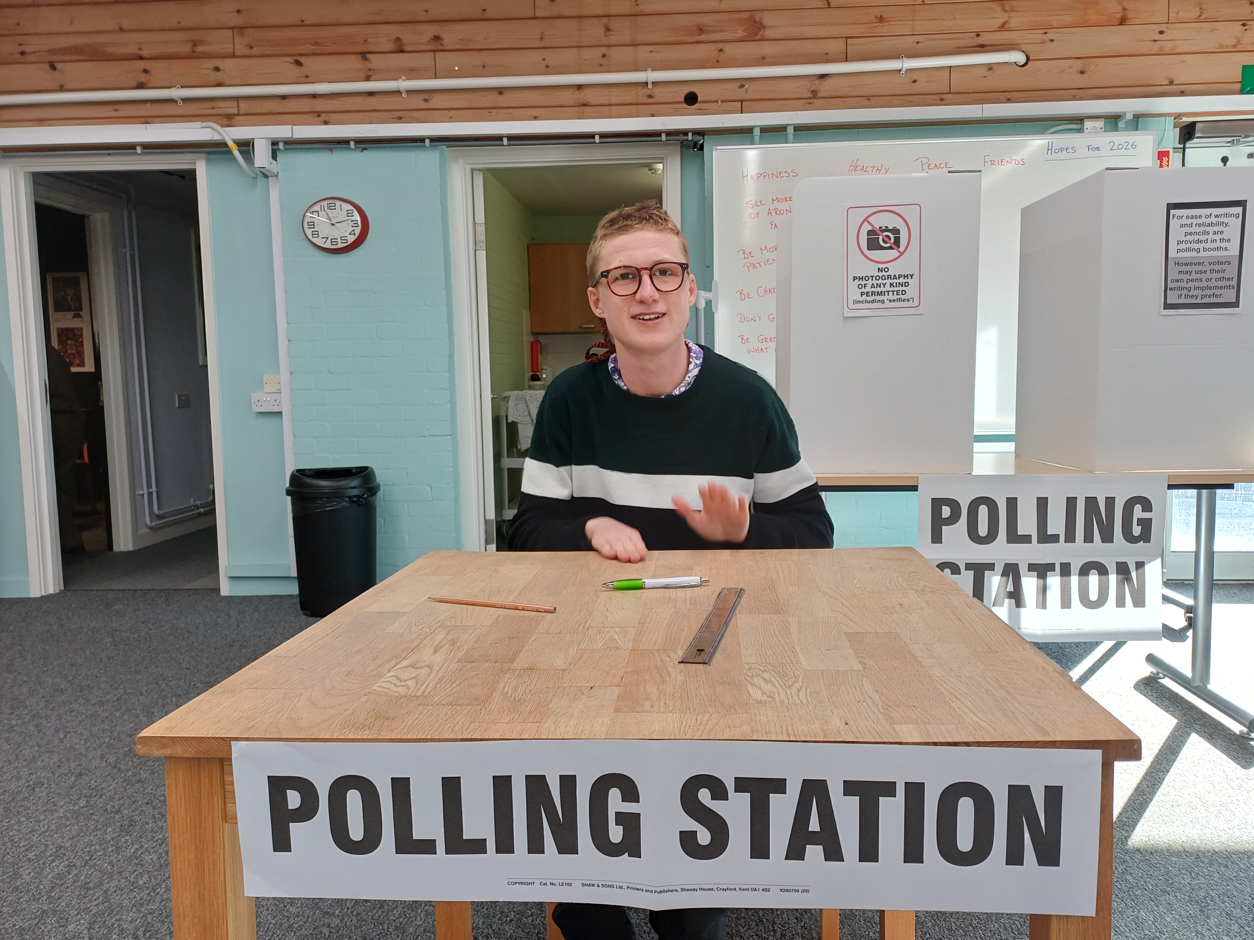 Customer sitting in front of 'polling station' box