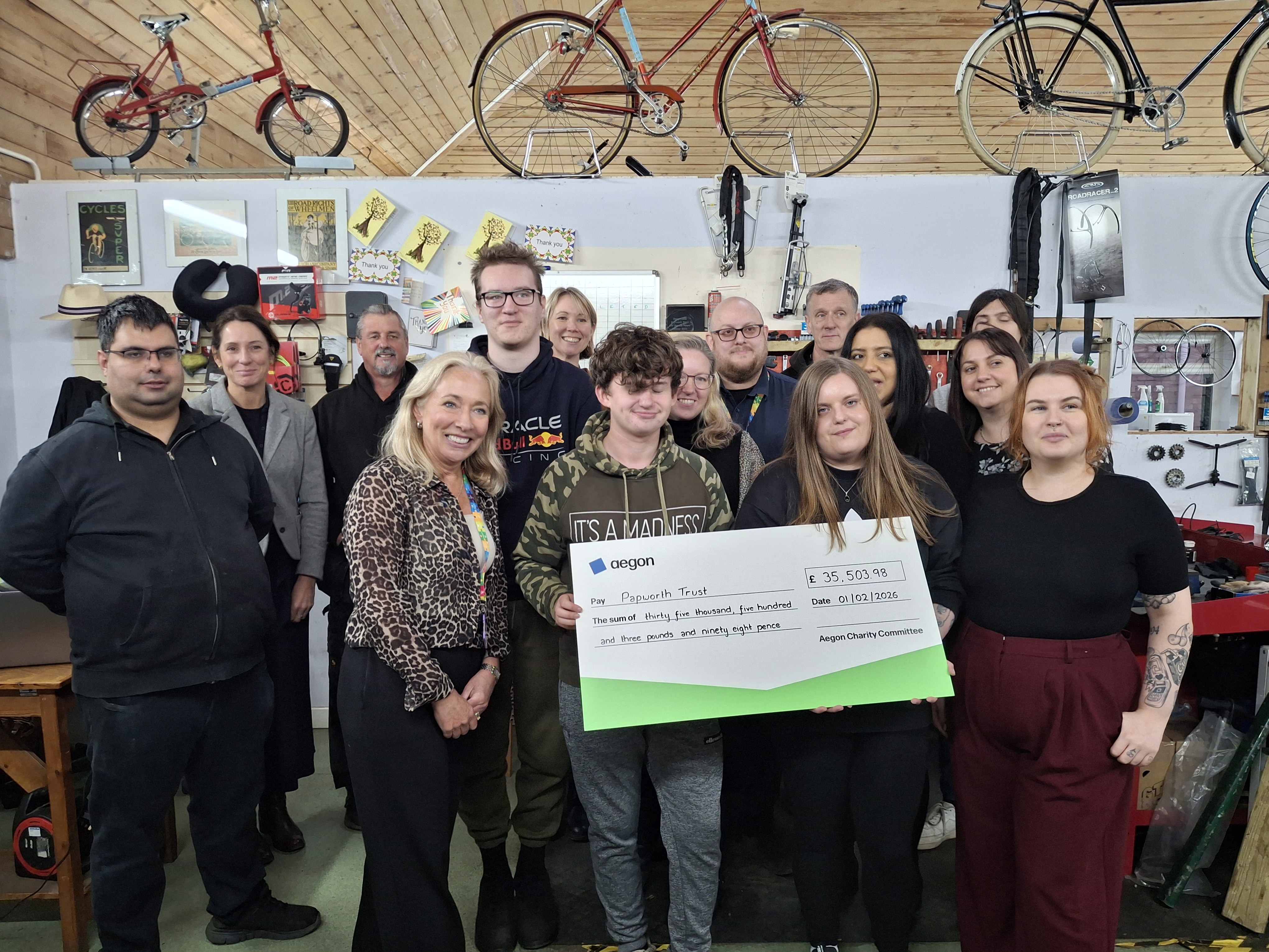 An image of our Fundraiser Pippa standing with the team from Aegon who are holding a cheque