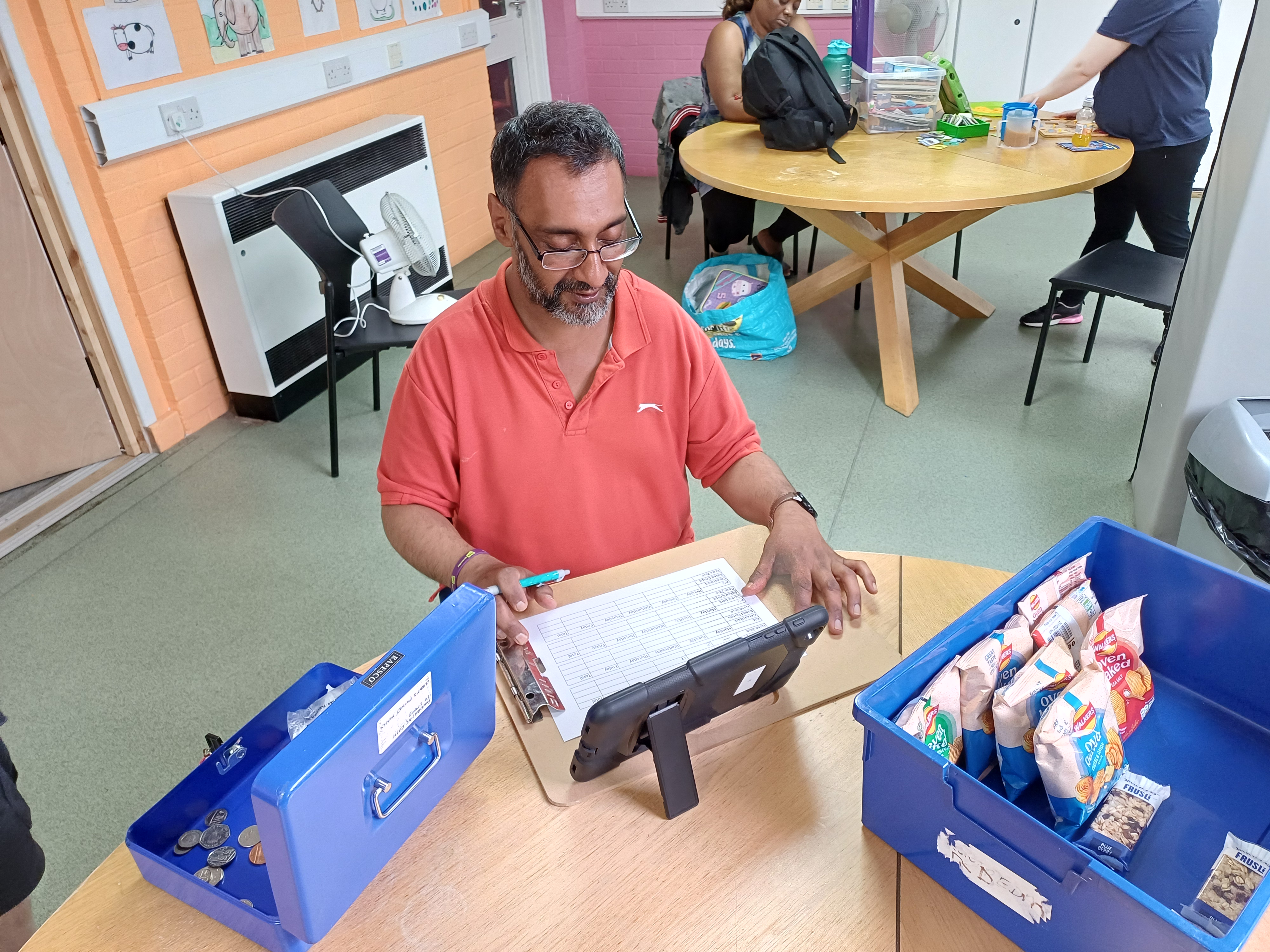 Kulbir working the tills at the tuck shop at the centre