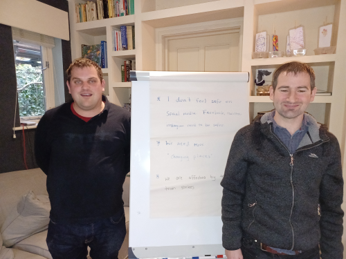 Two customers standing near a whiteboard with their message