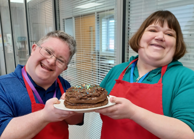 Customers holding a chocolate cake