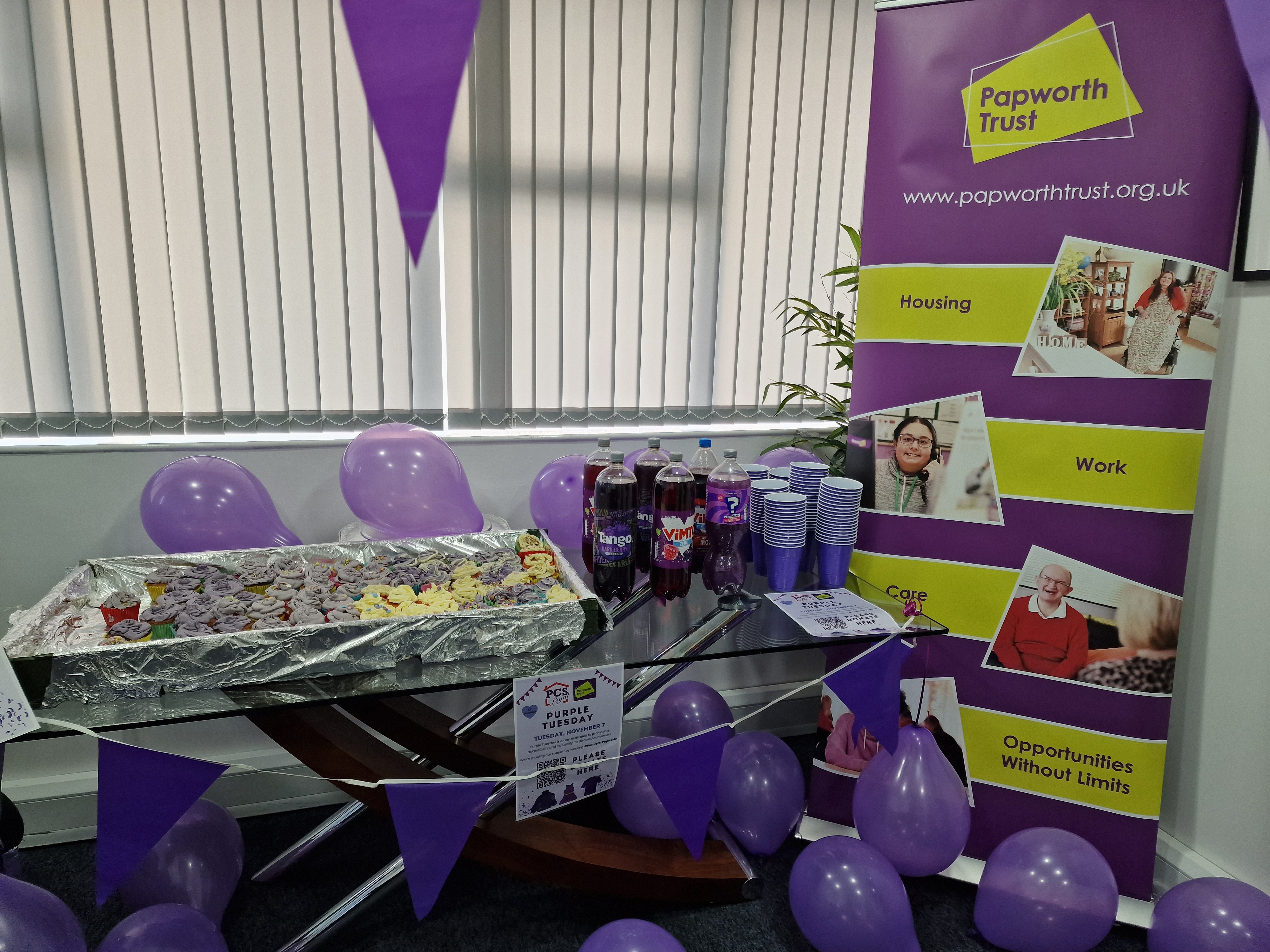 Desk with cupcakes and Papworth Trust banner