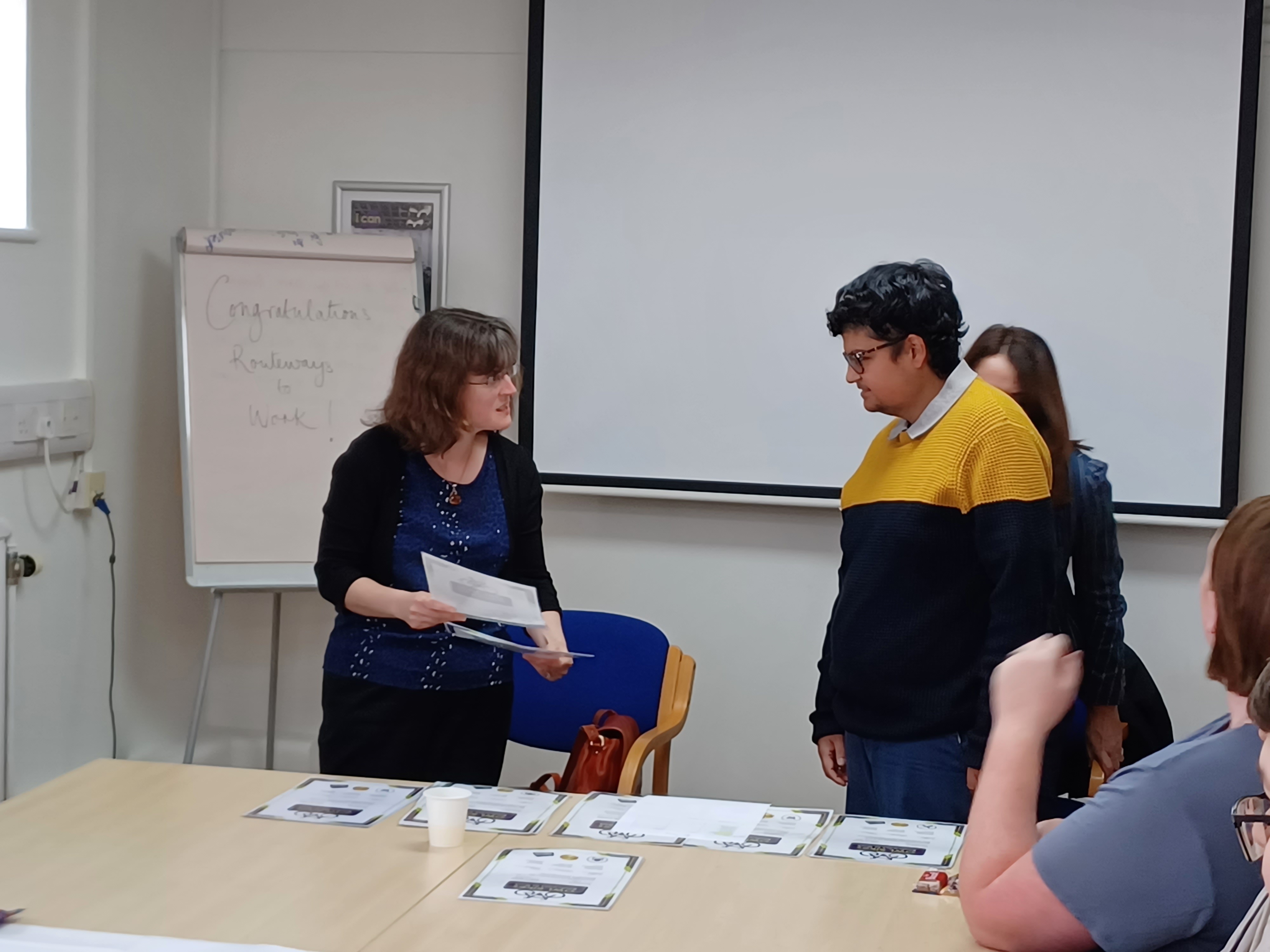 Image of a trustee giving a certificate to a participant