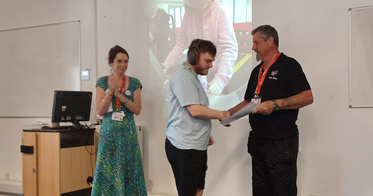A photo of Fleur and Barry presenting a customer with a certificate.