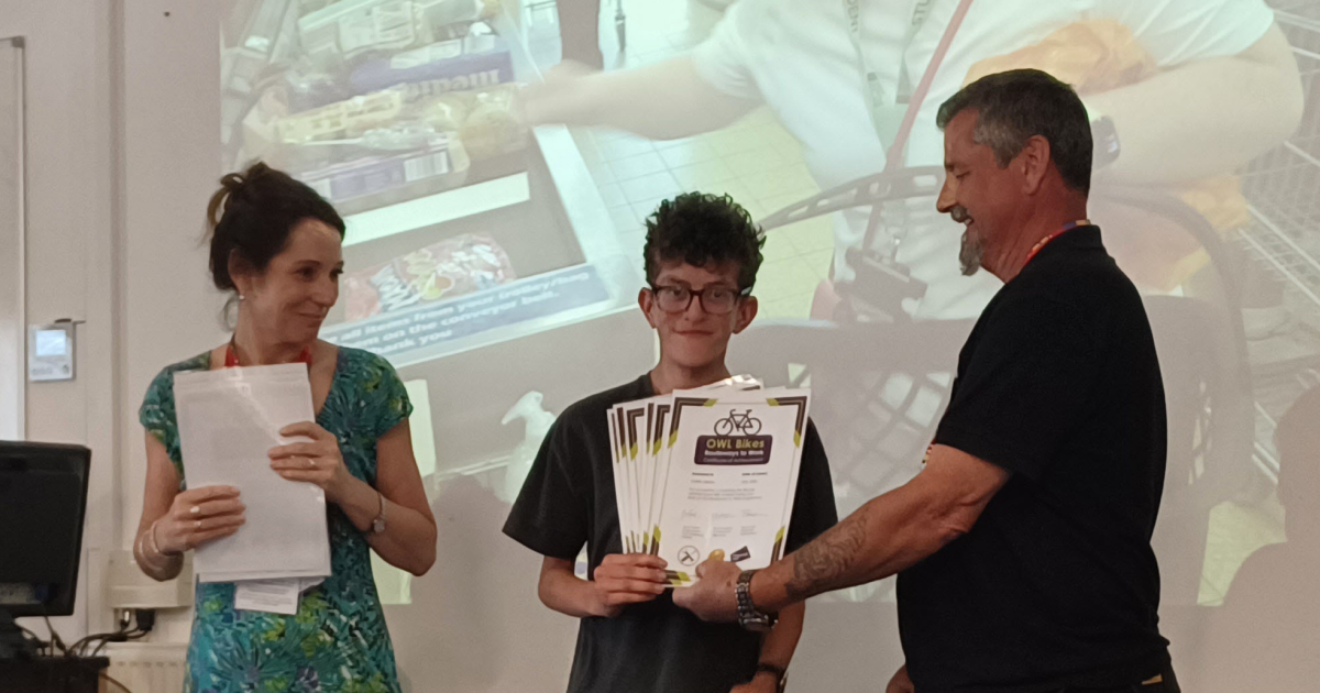 A photo of Fleur and Barry presenting a customer with a certificate.