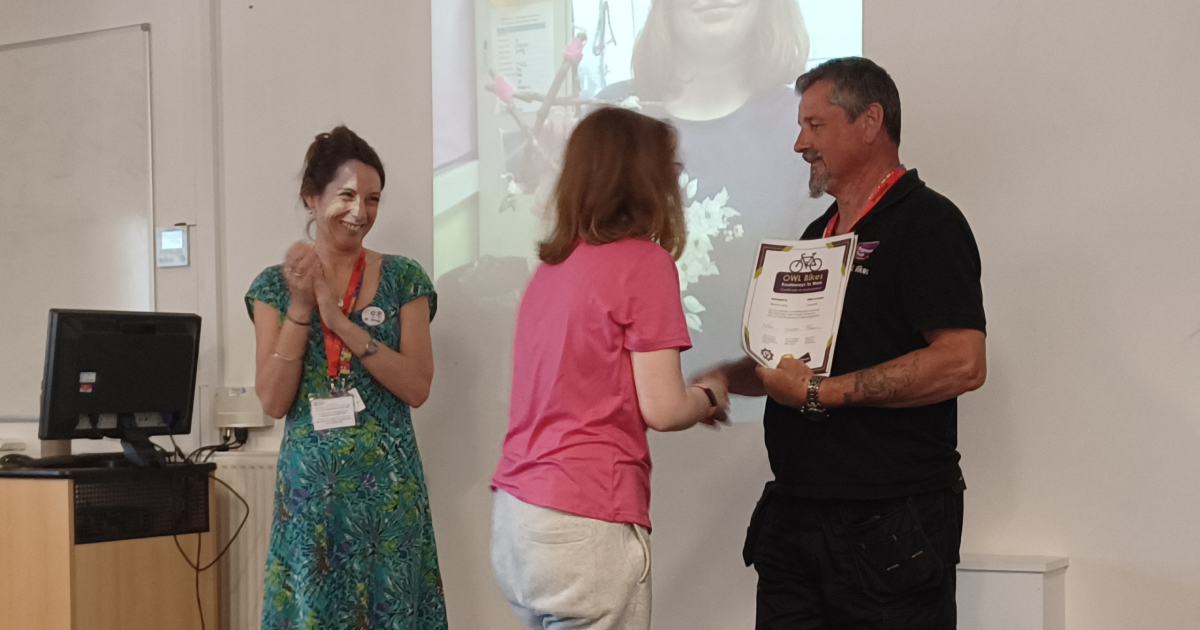 A photo of Fleur and Barry presenting a customer with a certificate.