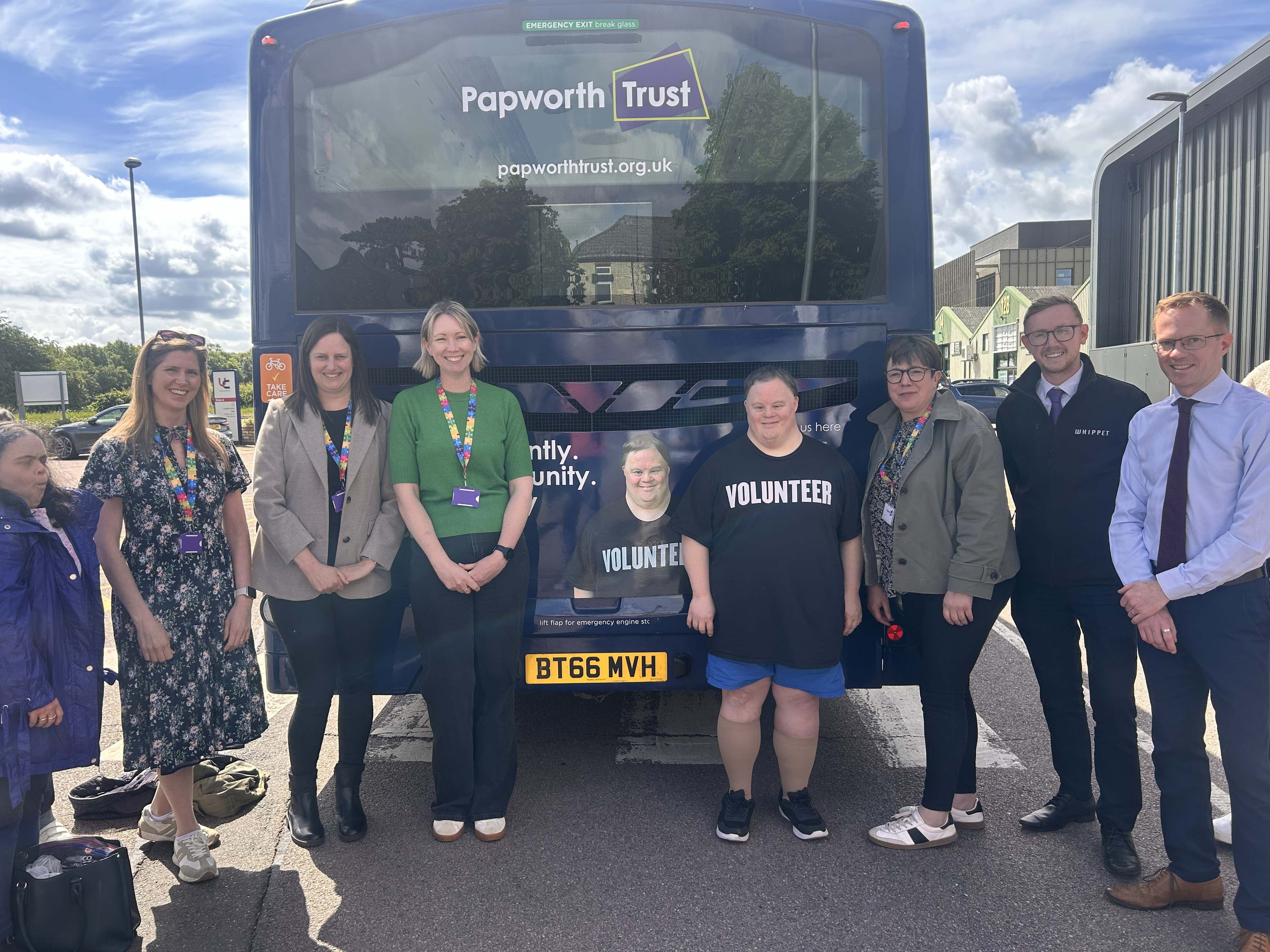 A group of people standing in front of a bus